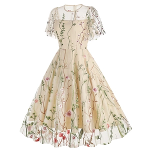 Close-up of colorful floral embroidery on champagne mesh tulle cocktail dress