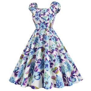 Detail of vintage A-line dress featuring white fabric with blue floral and green leaf patterns
