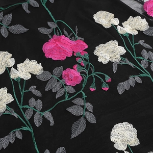 Detail of floral embroidery on black mesh with pink and white roses on a vintage V-neck dress