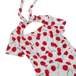 Detail of vintage white summer dress with red cherry pattern and halter neck bow design