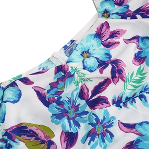 Detail shot of invisible zipper and fine stitching on white floral print dress