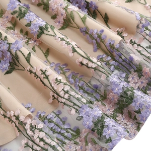 Macro shot of detailed floral embroidery on sheer mesh fabric of a vintage V-neck dress