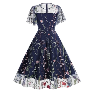 Close-up of intricate floral embroidery on navy blue mesh layers of the retro dress