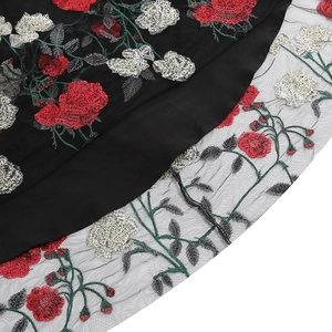 Detail of red floral embroidery on black mesh fabric with vintage V-neck dress texture