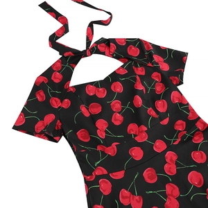 Detail view of vintage black floral dress with red cherry print and halter neck design