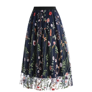 Macro shot of colorful floral embroidery and delicate mesh layers on a high waist skirt