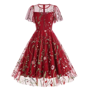 Intricate floral embroidery detail on dark red mesh fabric for vintage dress