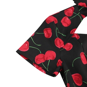Close-up of vintage black dress sleeve featuring vibrant red cherry floral prints