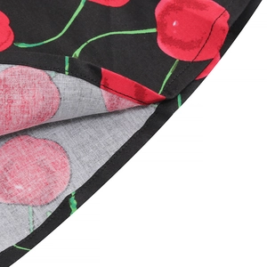 Close-up of vintage cherry print fabric with detailed double-stitched hem on black dress