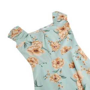 Detail view of mint green floral dress featuring puffed sleeves and square neckline