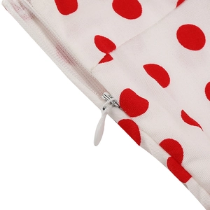 Close-up of white invisible zipper with teardrop pull on red polka dot vintage fabric
