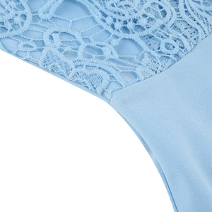Detail of light blue dress showing lace floral embroidery and smooth fabric stitching