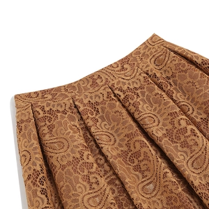Detailed macro view of vintage brown paisley lace fabric and pleated texture on a skirt