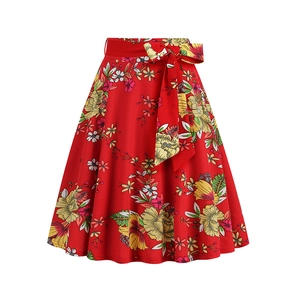 Detail of red floral A-line skirt with high waist belt and vibrant tropical leaf print