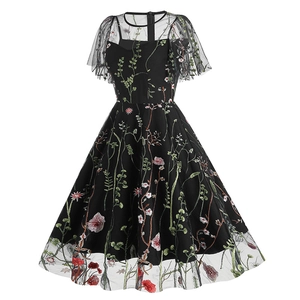 Close-up of intricate floral embroidery and sheer mesh texture on black vintage dress