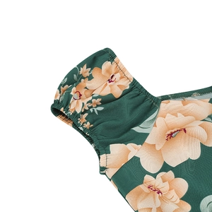 Detail view of vintage puff sleeves with floral print on a dark green square neck dress