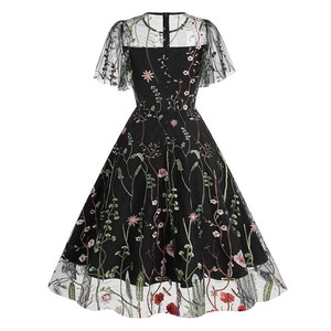 Close-up of floral embroidery on black mesh sleeves and crew neck of the vintage dress