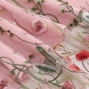 Detail van een roze mesh jurk met 3D bloemenborduurwerk en groene wijnrankpatronen