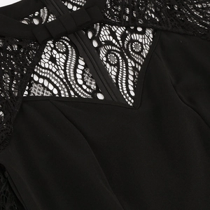 Detail of black lace neckline with elegant swirl patterns and a flat bow on the back