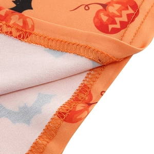 Macro view of overlock stitching on orange Halloween dress with pumpkin and bat patterns