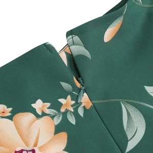 Detailed close-up of invisible zipper on dark green floral vintage dress fabric