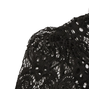 Detailed macro shot of the black floral lace fabric with intricate hollow-out embroidery