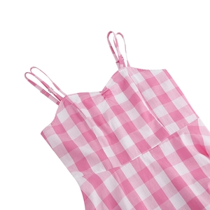Detail of pink plaid dress featuring adjustable spaghetti straps and pleated neckline