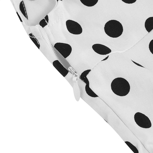 Detailed close-up showing the invisible zipper and black polka dot pattern on white fabric