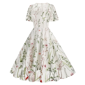 Close-up of intricate floral embroidery on white mesh fabric of short sleeve evening gown