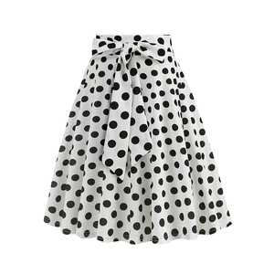 Close-up of high-waist A-line skirt with black polka dots and large decorative bow tie