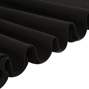 Close-up of black lace dress fabric with elegant pleated hem and wavy texture details