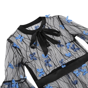 Close-up of black mesh fabric with blue butterfly appliques and a satin bow collar
