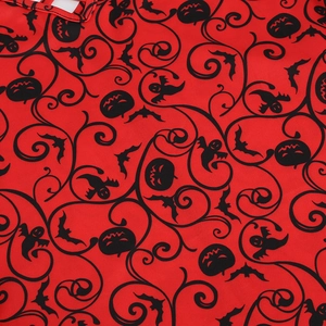 Close-up of red Halloween dress fabric with pumpkin, bat, and ghost print details