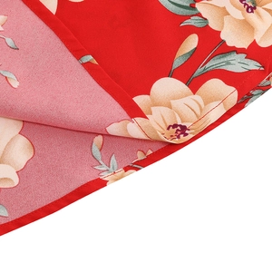 Detailed close-up of floral print on red fabric showing fine stitching and hemline