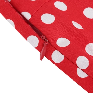 Detailed close-up of a seamless red concealed zipper on a vintage polka dot dress fabric