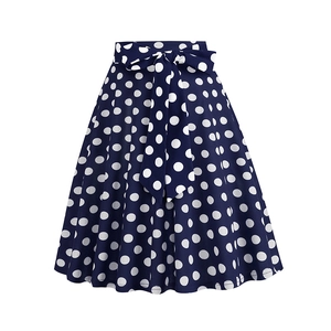 Detail of high-waist vintage navy A-line skirt with white polka dots and a tied bow belt