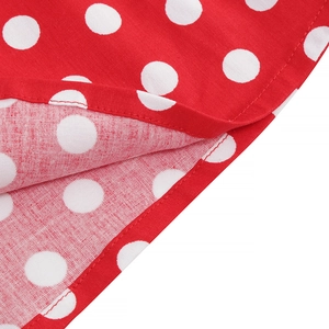 Close-up detail of red polka dot vintage dress fabric with neat stitching and cotton texture