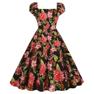 Close-up of vintage floral print with pink roses on black fabric and square neckline