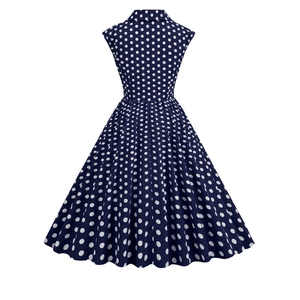 Rear view of a vintage navy blue polka dot 1950s swing dress with a high waist cut