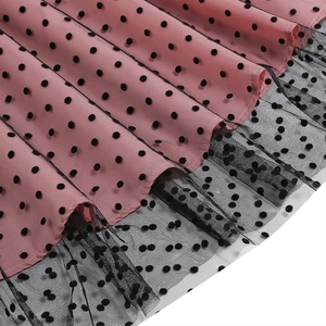 Detailed view of layered pink and black polka dot mesh fabric with pleated design