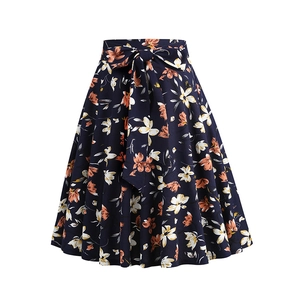 Detail of high-waist A-line floral skirt with a navy blue bow-tie belt and retro patterns