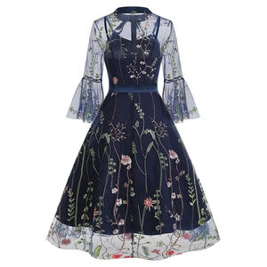 Detailed close-up of dark blue mesh dress featuring colorful floral embroidery and satin belt