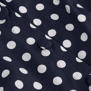 Detail of navy blue polka dot dress with fabric covered buttons and fine stitching