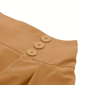 Detailed macro view of high-waisted camel skirt featuring three decorative side buttons