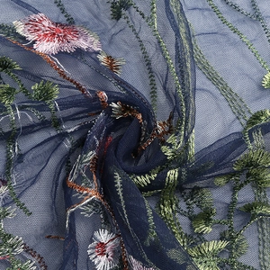 Detailed close-up of dark blue mesh fabric with elegant pink floral embroidery textures