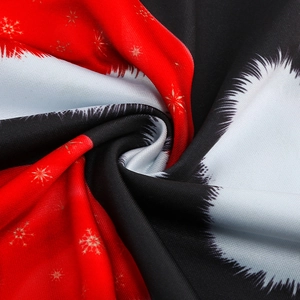 Close-up of red and black Christmas dress fabric with golden snowflake patterns