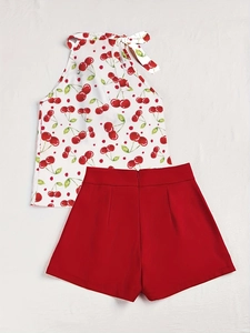 Detail von weißem Neckholder-Top mit Kirschprint und passenden roten Shorts für den Sommer