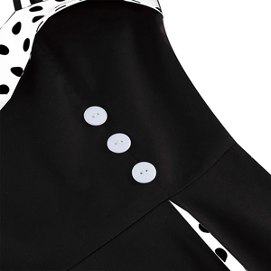 Detailed close-up of white buttons and polka dot patchwork on black vintage dress fabric