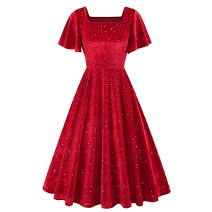Détail d'une robe en velours rouge avec paillettes argentées et manches volantées
