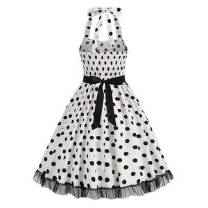 Detail of vintage polka dot dress featuring lace-stitched hem and large black waist bow